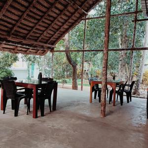 a group of tables and chairs in a pavilion at Molly's Hostel in Varkala