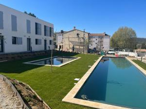 a large swimming pool in a yard next to a building at Les Papillons du Ventoux - L'Aurore de Provence - twee slaapkamerappartement met terras en tuin in Malaucène