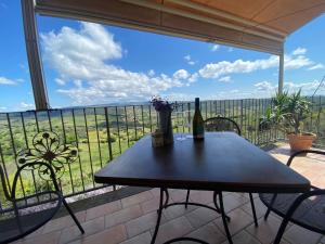 un tavolo con una bottiglia di vino sul balcone di Nettare e Ambrosia a Montiano