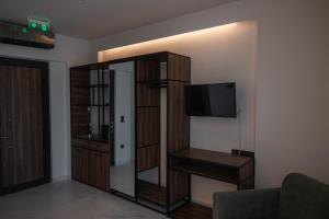 een woonkamer met een televisie en een boekenplank bij Salt Boutique Hotel in Palouki