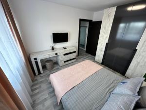 a small bedroom with a bed and a television at 1 Mai - Luxury Park Apartments - Self Check-in - Private parking - 1 in Craiova