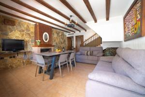 sala de estar con mesa y sofá en Casas Rurales Los Olivos, en Alcalá del Júcar
