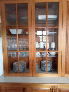 a cabinet filled with plates and dishes at Boyle's Beach House - Fully furnished 3 Bedroom home. Secure parking. in Nambucca Heads