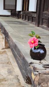 Un jarrón con una flor en él sentado en una cornisa en Hanok Soeun House en Miryang