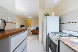 a kitchen with white appliances and a white refrigerator at Viaggiato Gama in Cordoba