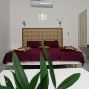 Un dormitorio con una cama con sábanas moradas y una planta en Leaf Garden Retreat, en Varkala