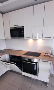 eine Küche mit weißen Schränken und einer schwarzen Mikrowelle in der Unterkunft Casa Lidia Costa Calma beach in Costa Calma