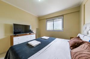 a bedroom with a bed and a flat screen tv at Viaggiato Gama in Cordoba