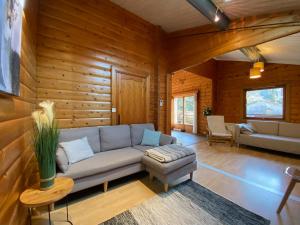 salon z kanapą i stołem w obiekcie Chalet les Bleuets 12p - babyfoot & Wii w mieście Gérardmer