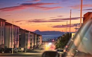 英雄港Charme Apartment Center的一条城市街道,在日落时分,在街上停车