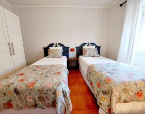two beds sitting in a room with at Charme Apartment Center in Angra do Heroísmo