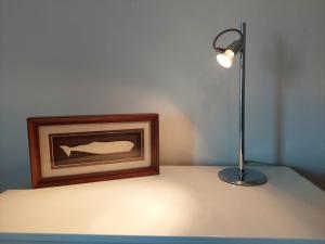 a lamp sitting on a table next to a picture at Charme Apartment Center in Angra do Heroísmo