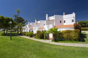 a large white house with a green lawn at Vila Senna in Vale do Lobo