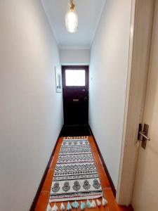 a hallway with a black door with a tile floor at Charme Apartment Center in Angra do Heroísmo