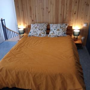 Bett in einem Zimmer mit zwei Lampen an zwei Tischen in der Unterkunft Chez BEN avec tout le confort clim wifi Netflix gratuit in Castres