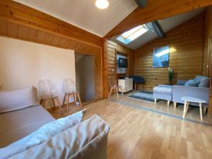 salon z łóżkiem i kanapą w obiekcie Chalet les Bleuets 12p - babyfoot & Wii w mieście Gérardmer