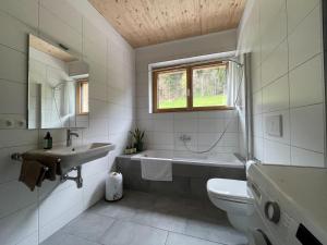 La salle de bains est pourvue d'une baignoire, d'un lavabo et de toilettes. dans l'établissement Gamsfels Josephine Galeriewohnung, à Langen bei Bregenz