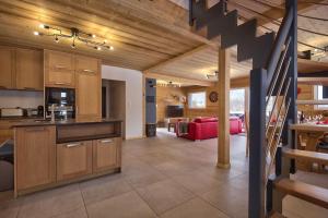 cocina y sala de estar con techos de madera y escalera en Chalet La Trinité-Spa,Sauna,Pétanque-Gérardmer, en Gérardmer