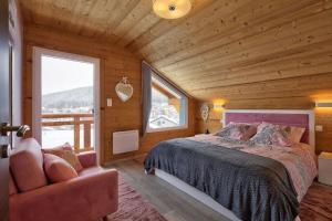 a bedroom with a bed and a chair and a window at Chalet La Trinité-Spa,Sauna,Pétanque-Gérardmer in Gérardmer