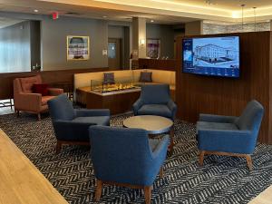 a waiting room with chairs and a flat screen tv at AmericInn by Wyndham Mountain Home in Mountain Home