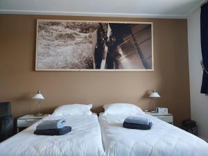 two beds in a room with a picture on the wall at B&B Pension "Op'e Koai" in Jirnsum