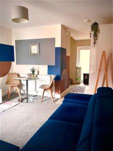 a living room with a blue couch and a table at 1 Bed House at Velvet Serviced Accommodation Swansea with Free Parking & WiFi - SA1 in Swansea