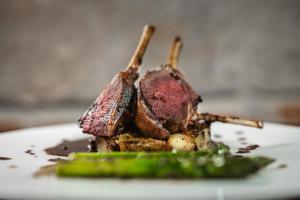 ein Stück Fleisch auf einem Teller mit Spargel in der Unterkunft Hotel Polski Pod Białym Orłem in Krakau