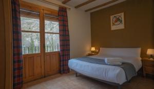 - une chambre avec un lit et une grande fenêtre dans l'établissement Casas Rurales Olmeda, à Alcalá del Júcar