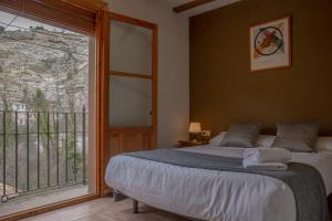アルカラ・デル・フカルにあるCasas Rurales Olmedaのベッドルーム1室(ベッド1台、大きな窓付)