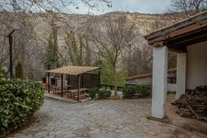 アルカラ・デル・フカルにあるCasas Rurales Olmedaの山を背景にした避難所付きの建物