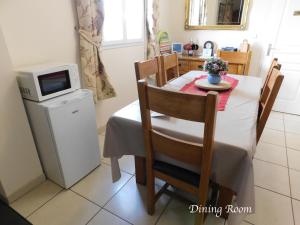 a kitchen with a dining room table with a microwave at Moonflower House in Rohan