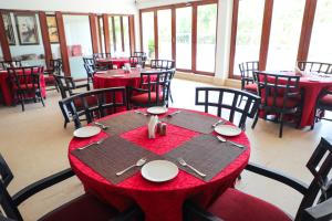 a dining room with red tables and chairs at White Pearl Suites by Rosetum in Old Goa