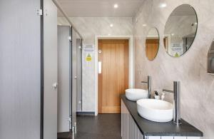 a bathroom with two sinks and a mirror at 68 Degrees West Glamping in Brecon