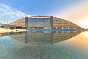 a large building with its reflection in the water at Grand Millennium Tabuk in Tabuk