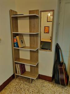 a book shelf in a room with a guitar at Secluded & green 2BHK in ancestral bunglow SCruz E in Mumbai