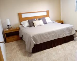 a bedroom with a large bed with two night stands at Los Cerezos de Ema in Puerto Iguazú