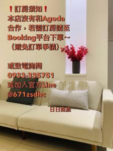 uma sala de estar com um sofá e uma parede com escrita em Day and Day Hotel No1 em Tianwei