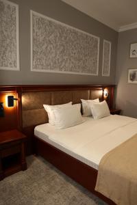 a bedroom with a large bed with white pillows at Mir Luxe Plaza in Tashkent