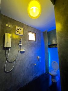 a bathroom with a shower with a toilet and a light at The Green Season Resort in Ban Mae Kham Lang Wat
