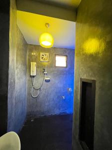 a bathroom with a shower with a yellow light at The Green Season Resort in Ban Mae Kham Lang Wat