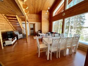 a dining room with a table and white chairs at Villa Kukka , LaatuLomat in Juva