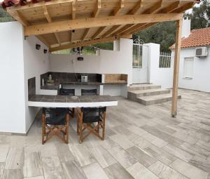 a patio with a table and chairs under a pergola at Garden house No1 in Plomari +35 photos