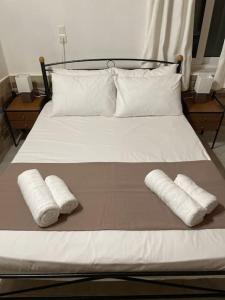 a bed with two pillows and two towels on it at Garden house No1 in Plomari