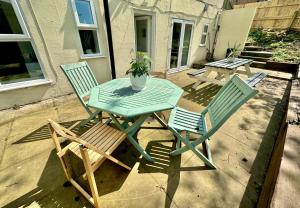 une table et des chaises assises sur une terrasse dans l'établissement Glen Fern Lodge - Garden Apartment with Parking - Heart of Town Centre - Close to Beach, à Bournemouth