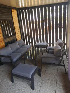 普利拉卡的住宿－Kamp Dalmacija，门廊配有两把椅子、一张沙发和一张桌子