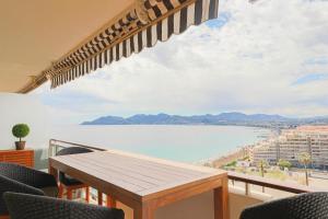 uma varanda com uma mesa e vista para a água em LE MEDITERRANEEN - Renovated apartment with sea view em Cannes