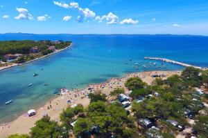 an aerial view of a beach with people in the water at Kamp Dalmacija in Privlaka