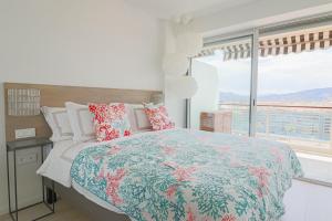 um quarto com uma cama e uma grande janela em LE MEDITERRANEEN - Renovated apartment with sea view em Cannes