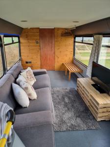 a living room with a couch and a tv at Dawel Nos Glamping in Sarnau
