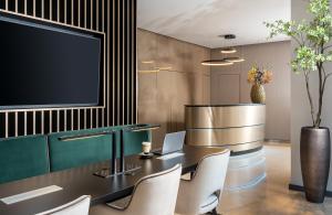 a conference room with a table and chairs and a tv at Leonardo Hotel Bucharest City Center in Bucharest
